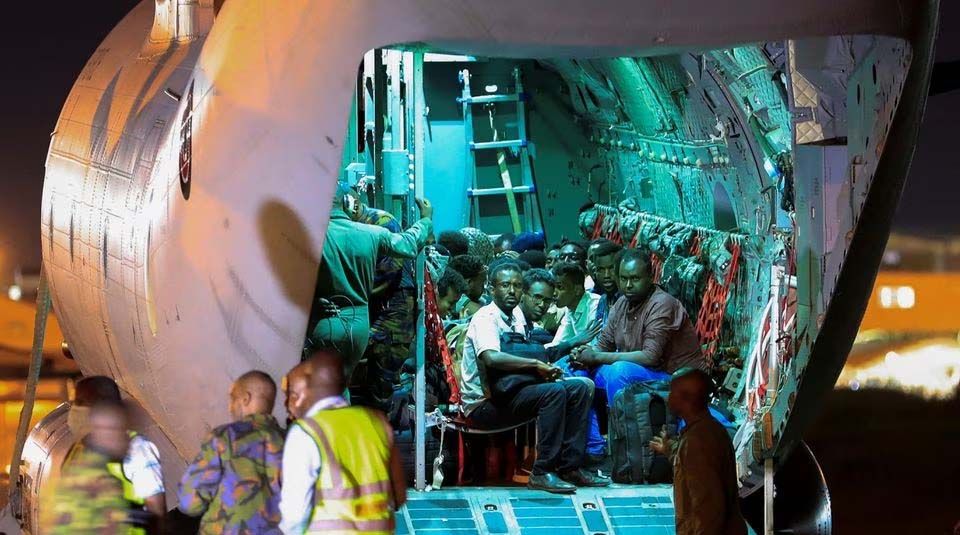 Para pengungsi dari Sudan yang dilanda perang duduk di dalam pesawat militer saat mereka menunggu untuk diproses oleh anggota Pasukan Pertahanan Kenya (KDF) setibanya mereka di Bandara Internasional Jomo Kenyatta di Nairobi, Kenya, 24 April.