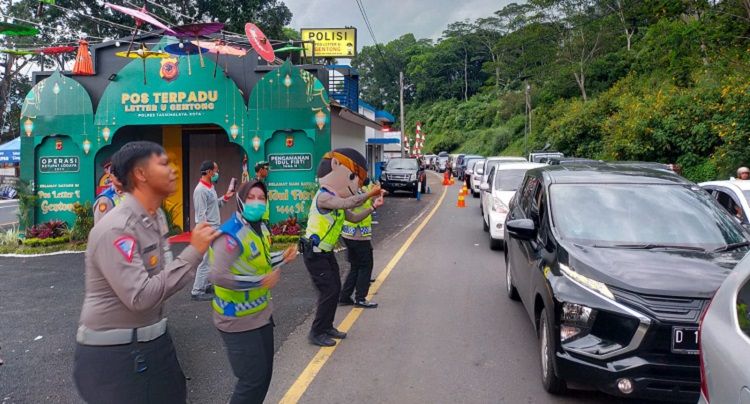 Polisi yang berjaga di jalur Gentong Kabupaten Tasikmalaya memberikan hiburan dengan alunan musik dan berjoget.*/kabar-priangan.com/Istimewa   