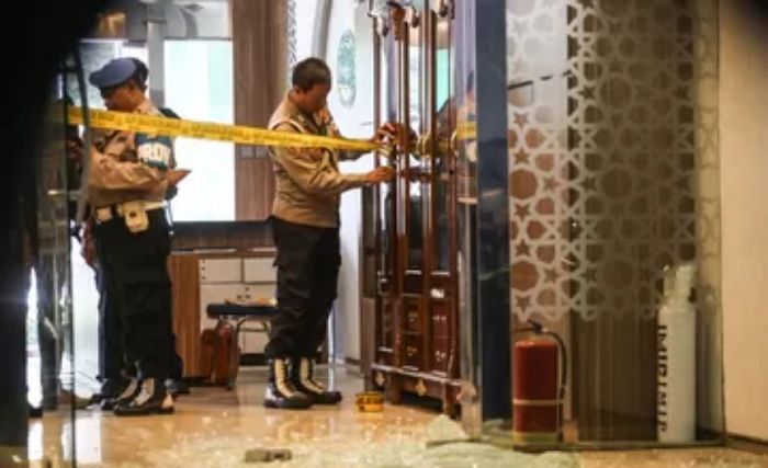 Anggota polisi memasang garis polisi di tempat kejadian perkara (TKP) dugaan penembakan di Kantor Majelis Ulama Indonesia (MUI) Pusat, Jakarta, Selasa (2/5/2023). /ANTARA FOTO/ Asprilla Dwi Adha/tom