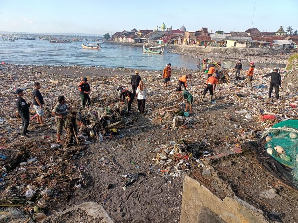 Earha gotong royong membersihkan sampah menumpuk yang mengotori muara Sungai Kalimoro di Desa Tembokrejo, Kecamatan Muncar