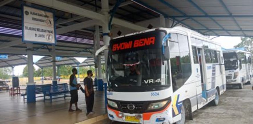 Penumpang akan naik ke dalam bus angkutan antar kota di luar Jawa 