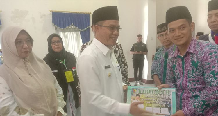 Bupati Bandung Dadang Supriatna berikan 'kadeudeuh' untuk calon jemaah haji asal Kabupaten Bandung di Lanud Sulaiman, Rabu 31 Mei 2023