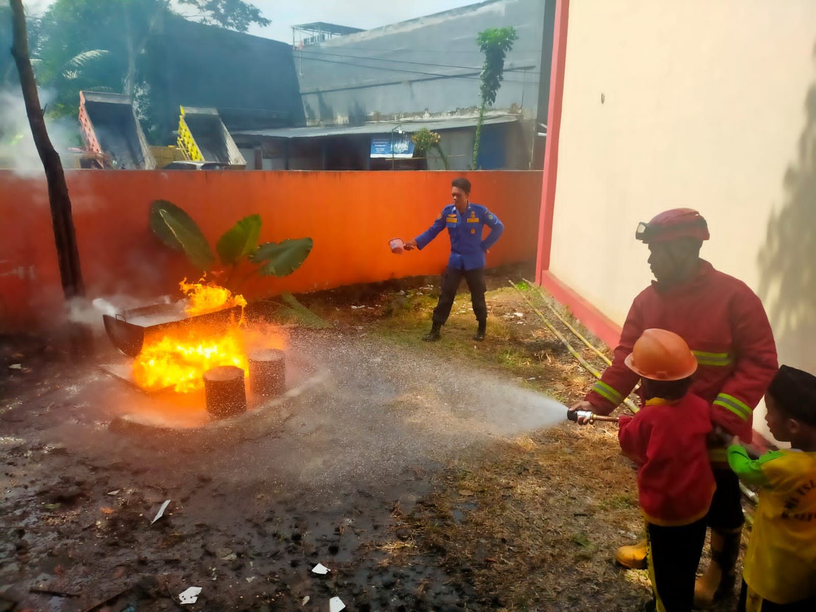 Tim damkar mengajak anak-anak MI Islamiyah Kalimandi untuk praktek langsung memadamkan api 