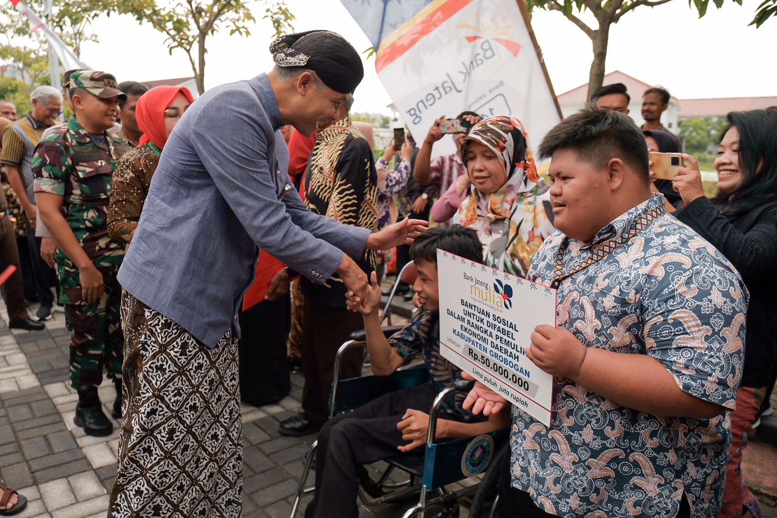 Gubernur Jawa Tengah, Ganjar Pranowo memberikan bantuan kepada para penerima manfaat di Taman Kota Purwodadi.