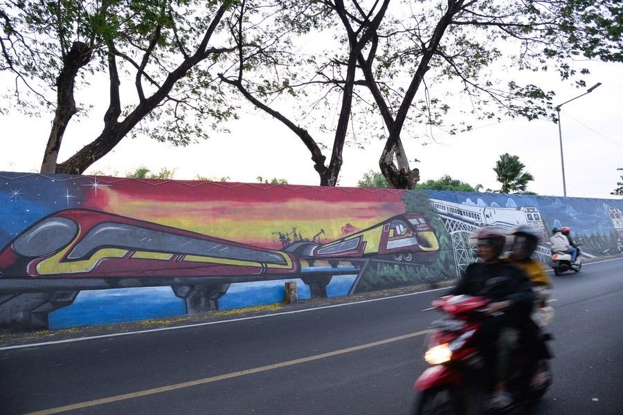 Foto yang diabadikan pada 6 Juni 2023 ini menunjukkan mural yang menampilkan berbagai jenis kereta di tepi Bengawan Madiun di Madiun, Provinsi Jawa Timur. (Xinhua/Xu Qin)