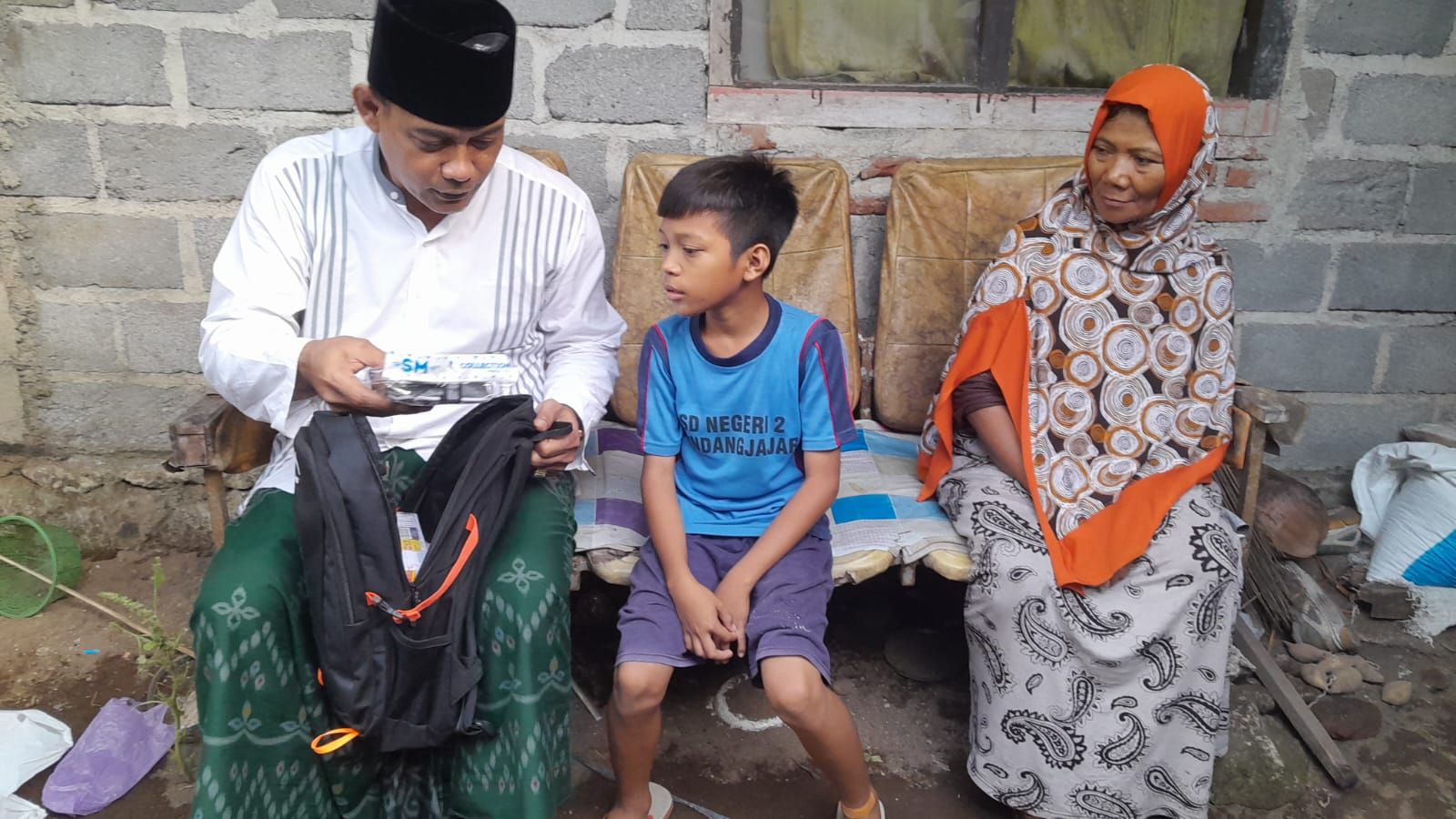 Ketua DPRD Pangandaran Asep Noordin menyerahkan paket bantuan sekolah kepada Ibrahim (12) siswa Kelas VI SD Negeri 2 Kondangjajar, Kecamatan Cijulang, Kabupaten Pangandaran, dan ibunya, Armilah (56).*/kabar-priangan.com/istimewa
