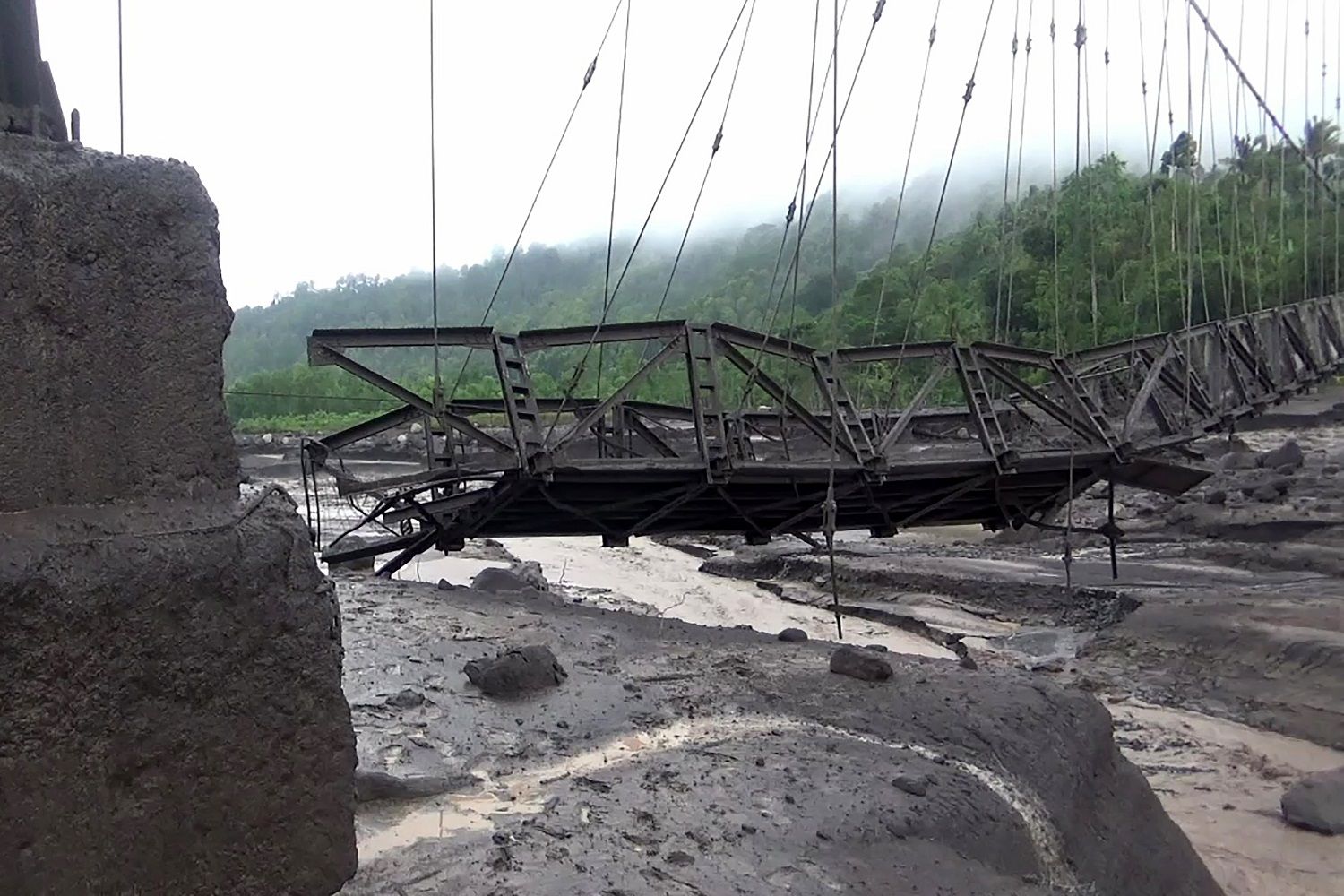 Kondisi Jembatan Gantung Kali Regoyo yang putus diterjang banjir lahar hujan di Sumber Wuluh, Lumajang, Jawa Timur, Jumat (7/7/2023). Akibat banjir lahar hujan Gunung Semeru tersebut menyebabkan sejumlah jembatan putus sehingga akses jalur Lumajang-Malang putus. ANTARA FOTO/Rohcmad/Zk/nym.