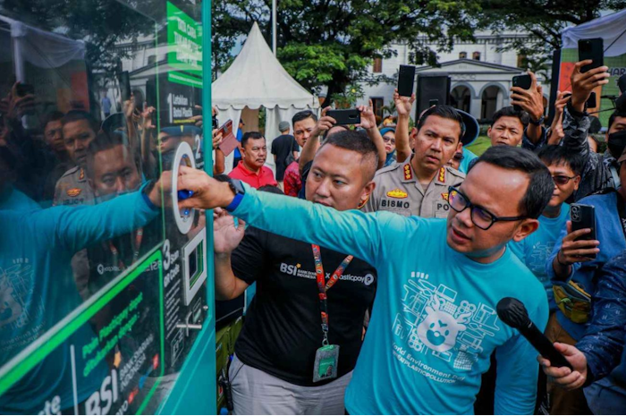 Bima Arya mencoba Mesin Penukaran Botol plastik pasca konsumsi dari BSI yang dalam kesempatan tersebut diserahkan Regional CEO Jakarta II PT Bank Syariah Indonesia (BSI) Tbk., Firman Jatnika pada peringatan Hari Lingkungan Hidup Sedunia di Alun-alun Kota Bogor, Jumat (7/7/2023).
