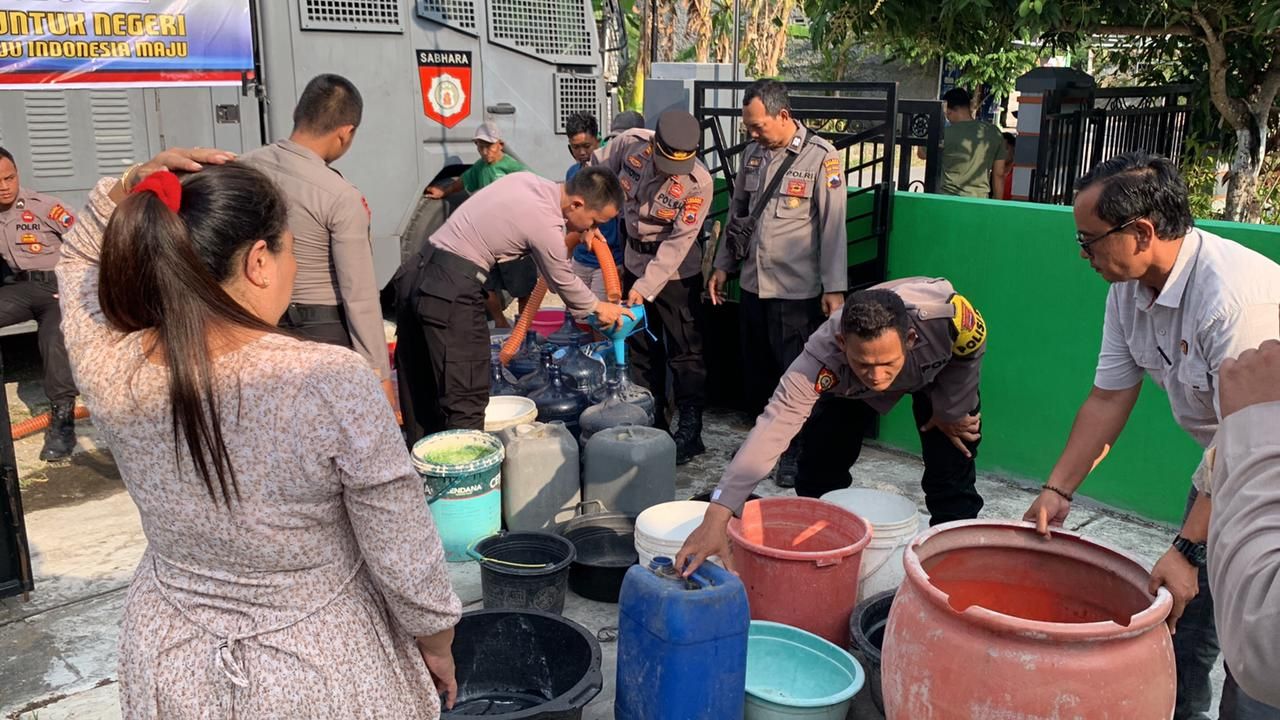 Warga antre mendapatkan air bersih bantuan dari Polres Grobogan.
