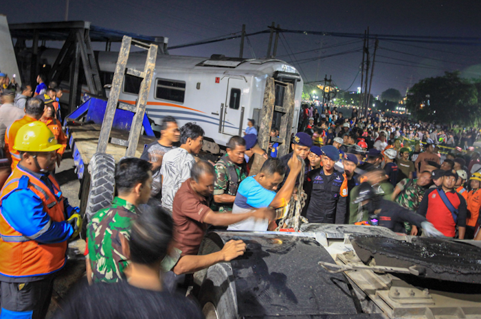 Petugas gabungan TNI, Polri, KAI, Pemadam Kebakaran Kota Semarang dan relawan berupaya mengevakuasi truk tronton bernomor polisi B 9934 IG yang tertabrak kereta api KA 112 Brantas.