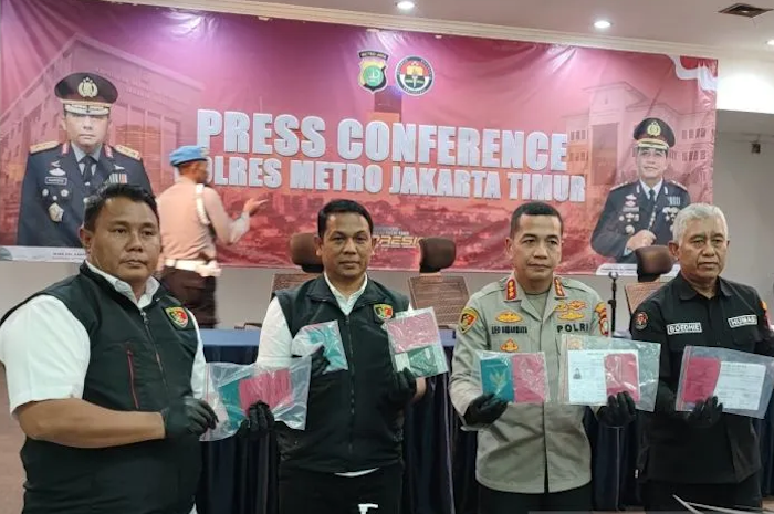 Kapolres Metro Jakarta Timur Kombes Pol Leonardus Simarmata (kedua kanan) saat memperlihatkan barang bukti paspor yang digunakan pelaku untuk menjadi pekerja migran Indonesia (PMI) ilegal di Mapolres Metro Jaktim, Jatinegara, Selasa (18/7/2023).