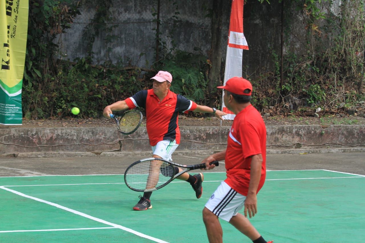 Pasangan Nazron/Komar saat melawan pasangan Dedi/Dede di turnamen tenis lapangan.