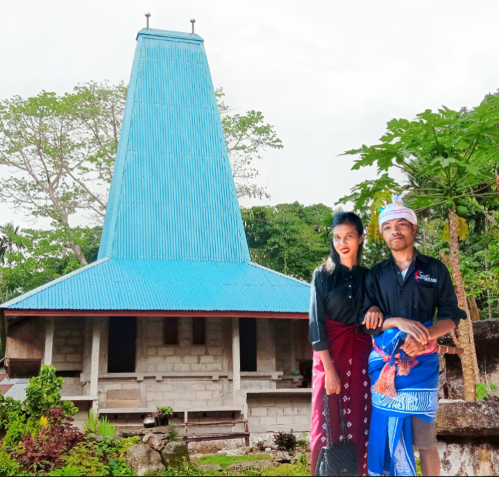 Jembor bersama pasangannya dengan latar Rumah adat Suku Wini Bero, SBD
