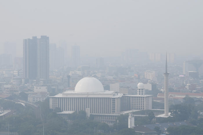 Suasana tugu Monas yang tertutup oleh kabut polusi di Jakarta.