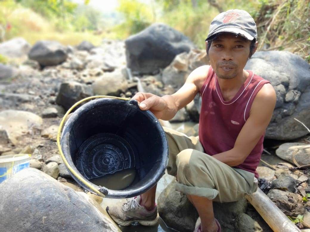 Hasan, seorang duda berumur 40 tahun, warga Desa Padarama, Kabupaten Kuningan, Jawa Barat, ditemui sedang mencari ikan di sungai Cigintung, Desa Sukaraja, dalam kondisi mengering akibat kemarau panjang, Kamis 10 Agustus 2023.*