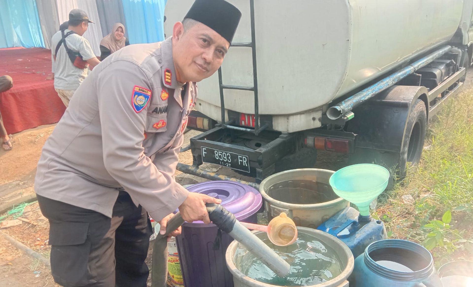 Kasat Binmas Polres Cimahi AKP Anang Suryana saat menyalurkan air bersih di Cipageran, Jumat 11 Agustus 2023.
