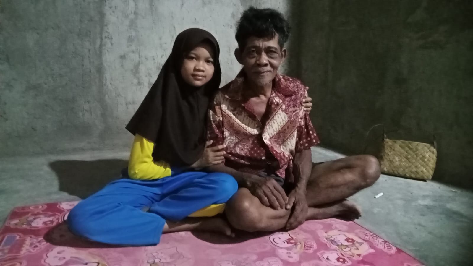 Marsini (10) bersama ayahnya, Darjo (60), di rumahnya yang sangat sederhana di Dusun Sukamanah RT 29 RW 08 Desa Kertamukti, Kecamatan Cimerak, Kabupaten Pangandaran, Sabtu 12 Agustus 2023.*/kabar-priangan.com/Kiki Masduki 
