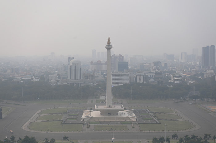 Suasana tugu Monas yang tertutup oleh kabut polusi di Jakarta.