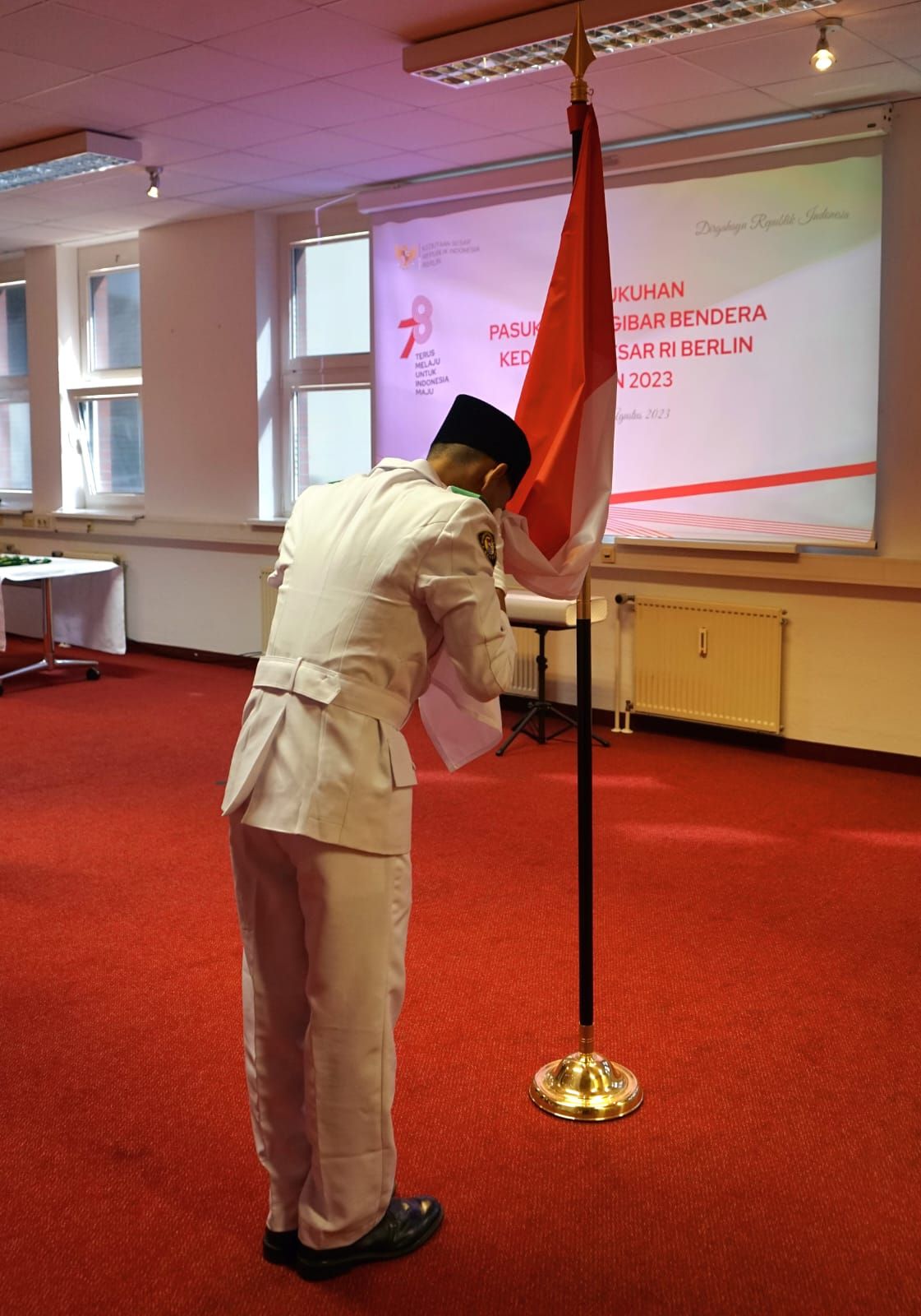 Salah satu anggota Paskibra mencium Bendera Merah Putih di KBRI Berlin Jerman.