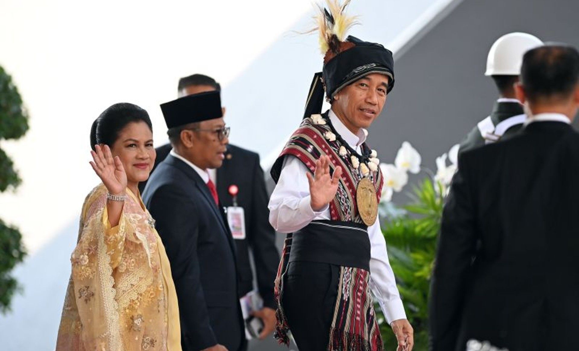 Presiden Joko Widodo mengenakan baju adat dari Tanimbar, Maluku (kanan) didampingi Ibu Iriana Joko Widodo melambaikan tangan saat tiba di lokasi Sidang Tahunan MPR dan Sidang Bersama DPR - DPD Tahun 2023