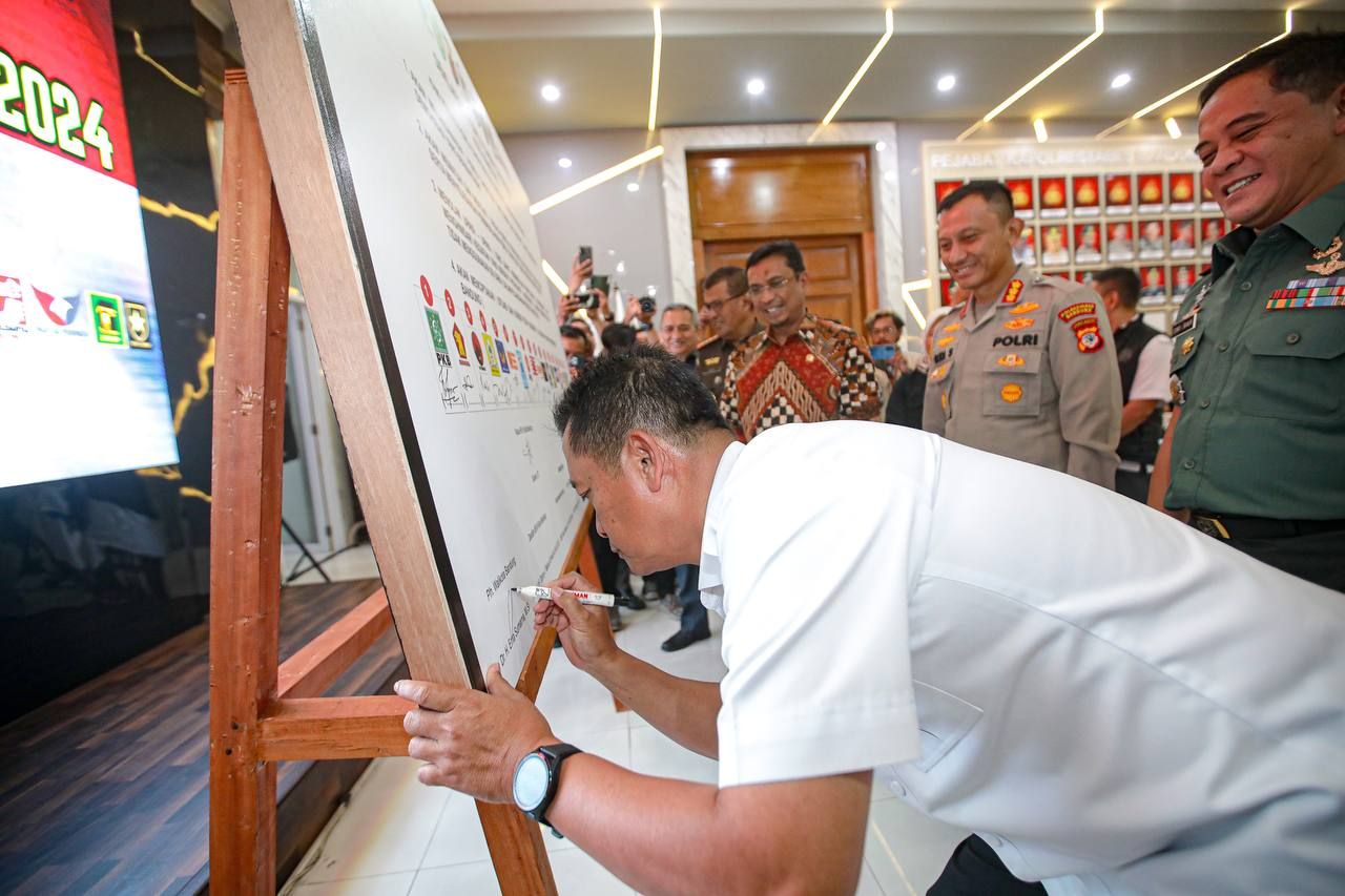 Plh Wali Kota Bandung Ema Sumarna saat menandatangani deklarasi damai parpol di Aula Mapolrestabes Kota Bandung./bandung.go.id