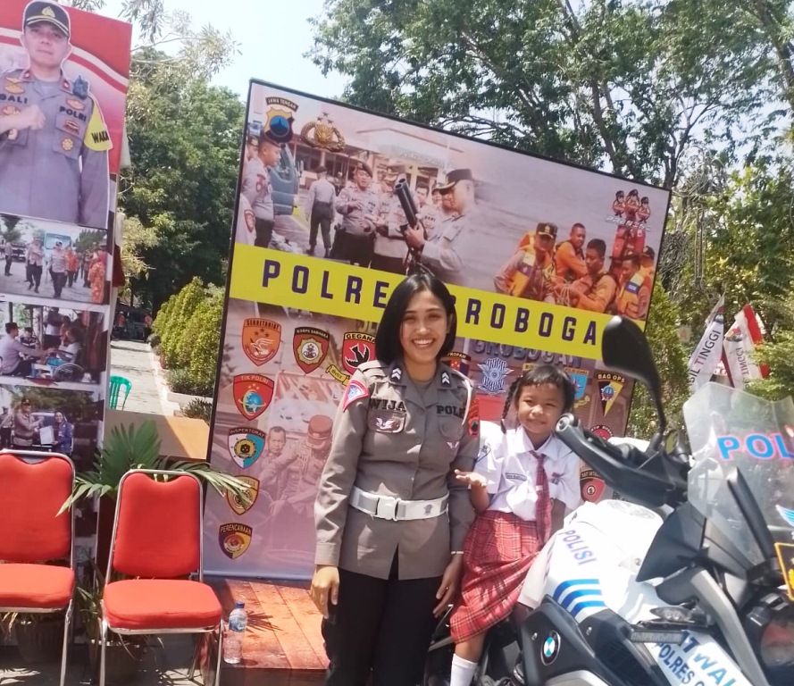Didampingi Polisi Wanita (polwan) siswi SD berfoto di stan Polres Grobogan  di Grobogan Expo 2023.
