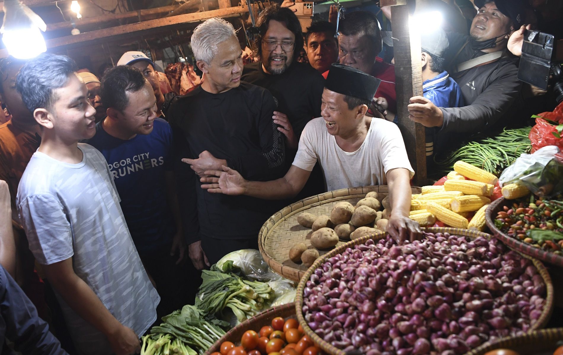 Gibran menemani capres Ganjar Pranowo saat berbincang dengan pedagang sayur di Pasar Citeureup, Kabupaten Bogor, Jawa Barat.