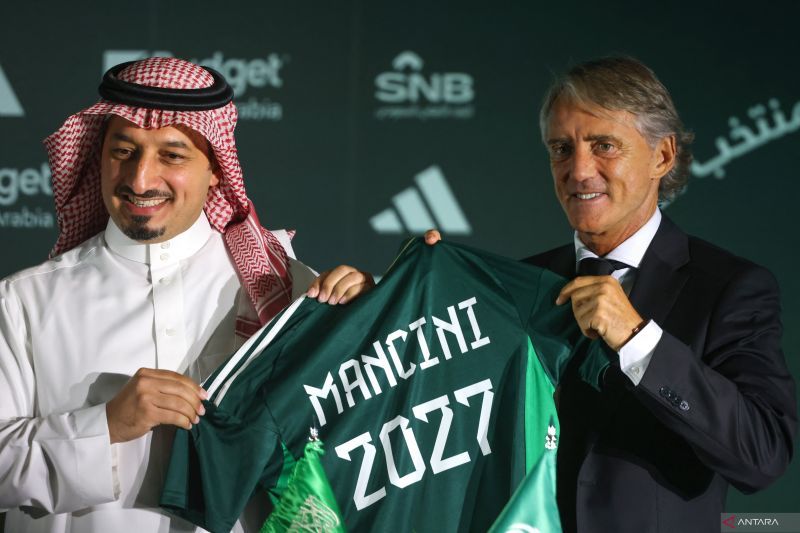 Presiden Federasi Sepak Bola Arab Saudi Yasser al-Misehal (kiri) dan pelatih baru timnas Arab Saudi Roberto Mancini (kanan) berpose untuk difoto pada konferensi pers dan penandatanganan kontrak kerja di Riyadh, Arab Saudi, Senin 28 Agustus 2023.