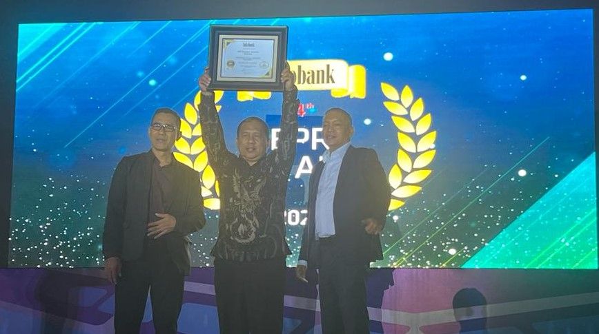 Direktur Utama Bank Kuningan, H. Dodo Warda tengah memperlihatkan penghargaan Infobank BPR Awards yang diterimanya.