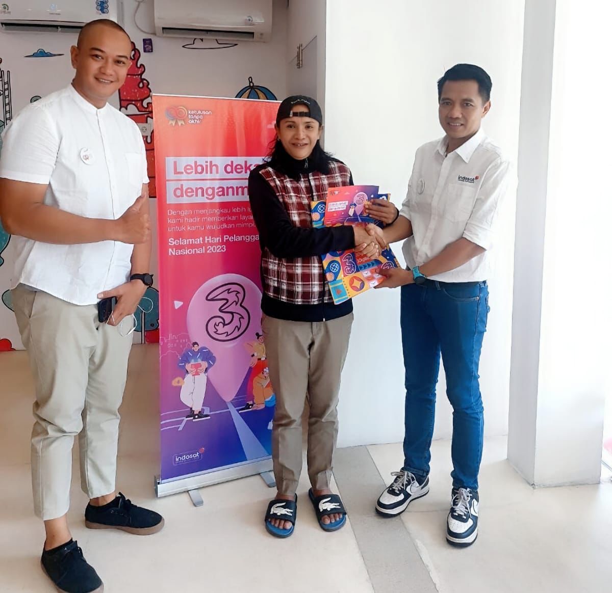 *Photo  Waskito Restu - Sr. Officer Area Sales Denpasar & Mayaram (Kiri) dan Isparyudi Prabowo - VP Head of Sales Jember & Bali (Kanan) berofoto beraama pelanggan Tri di 3Store Denpasar, Bali.(04/09/23)