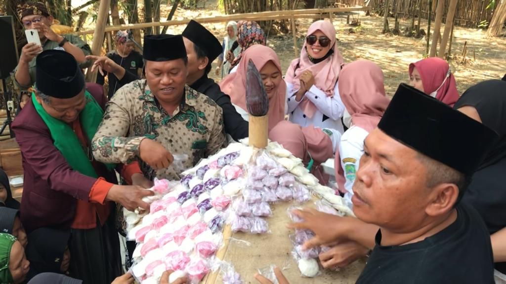  Sejumlah warga menikmati apem tolak bala di Blok Kaputren, Desa Putridalem, Kecamatan Jatitujuh, Kabupaten Majalengka, Rabu (13/8/2023).