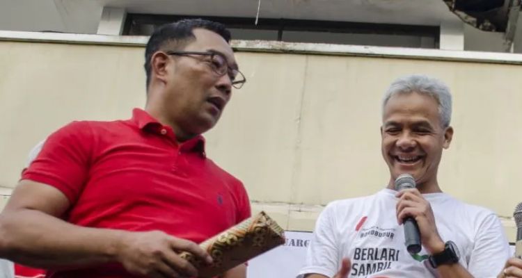 Ridwan Kamil (kiri) bersama Ganjar Pranowo (kanan) memberikan hadiah kepada warga saat acara Gerakan Jawa Barat Sehat di Kawasan hari bebas kendaraan Dago, Bandung, Jawa Barat, Minggu, 8 Maret 2020. 