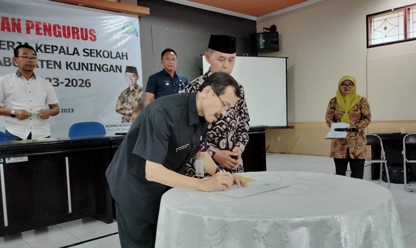 Kepala Disdikbud dan Ketua MKKS SMP Kabupaten Kuningan menandatangani berita acara pengukuhan.