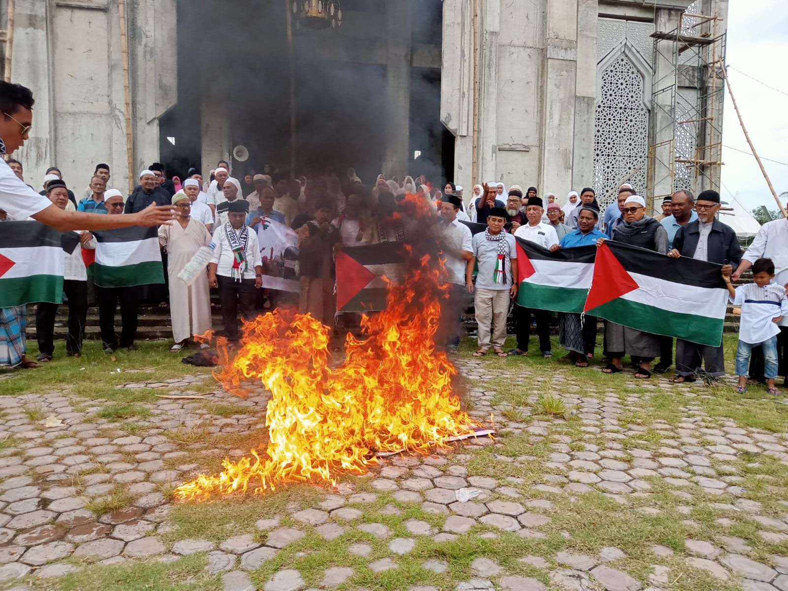Solidaritas masyarakat muslim Kota Lhokseumawe membakar bendera Israel sebagai bentuk kecaman atas aksi brutal terhadap Palestina