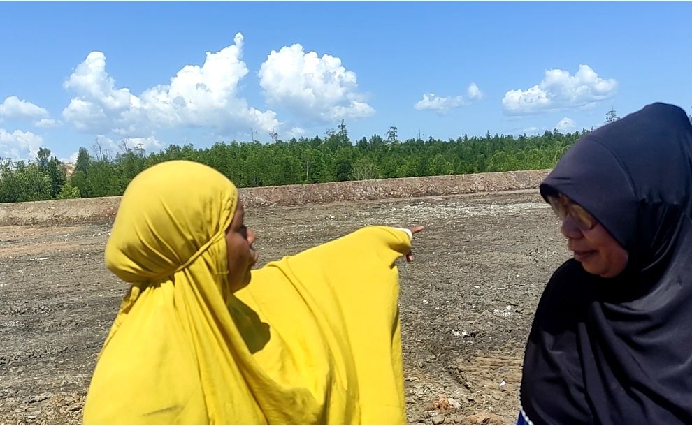 Lili (jilbab kuning) menunjujan kawasan mangrove yang digarap PT WIN dan kini dibuat seolah-olah menjadi empang. 