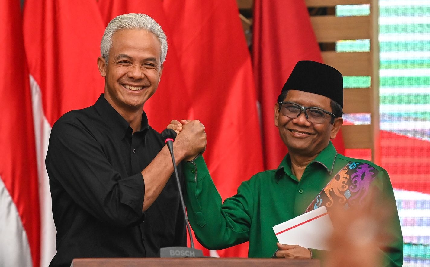 Bakal calon presiden dari PDI Perjuangan (PDIP) Ganjar Pranowo (kiri) dan bakal calon wakil presiden Mahfud MD (kanan) melakukan salam komando saat acara pengumuman bakal calon wakil presiden pada Pilpres 2024 di kantor DPP PDIP, Jakarta pada Rabu, 18 Oktober 2023.