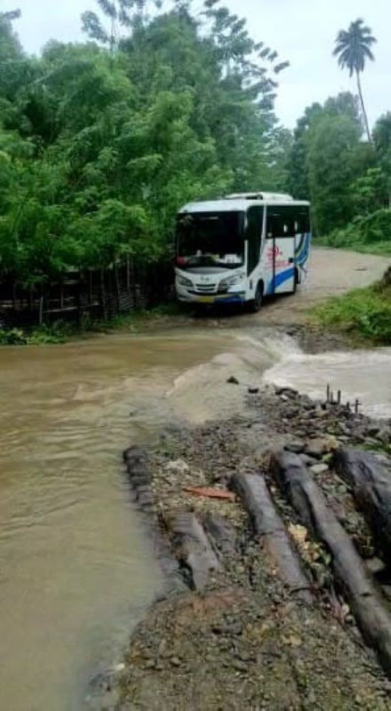 Bus perintis di Maluku yang hendak melalui kubangan jalan saat mengangkut penumpang. (Dok. Perum. Damri Cabang Ambon)