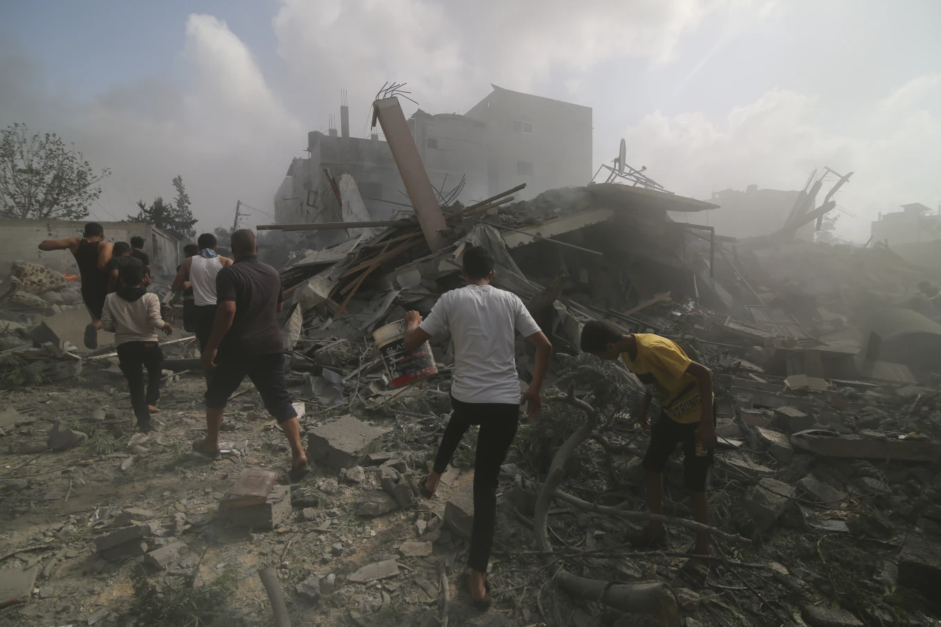 Warga Palestina mencari korban selamat di gedung-gedung yang hancur akibat bombardir Israel di Jalur Gaza di Rafah, Minggu, 22 Oktober 2023.