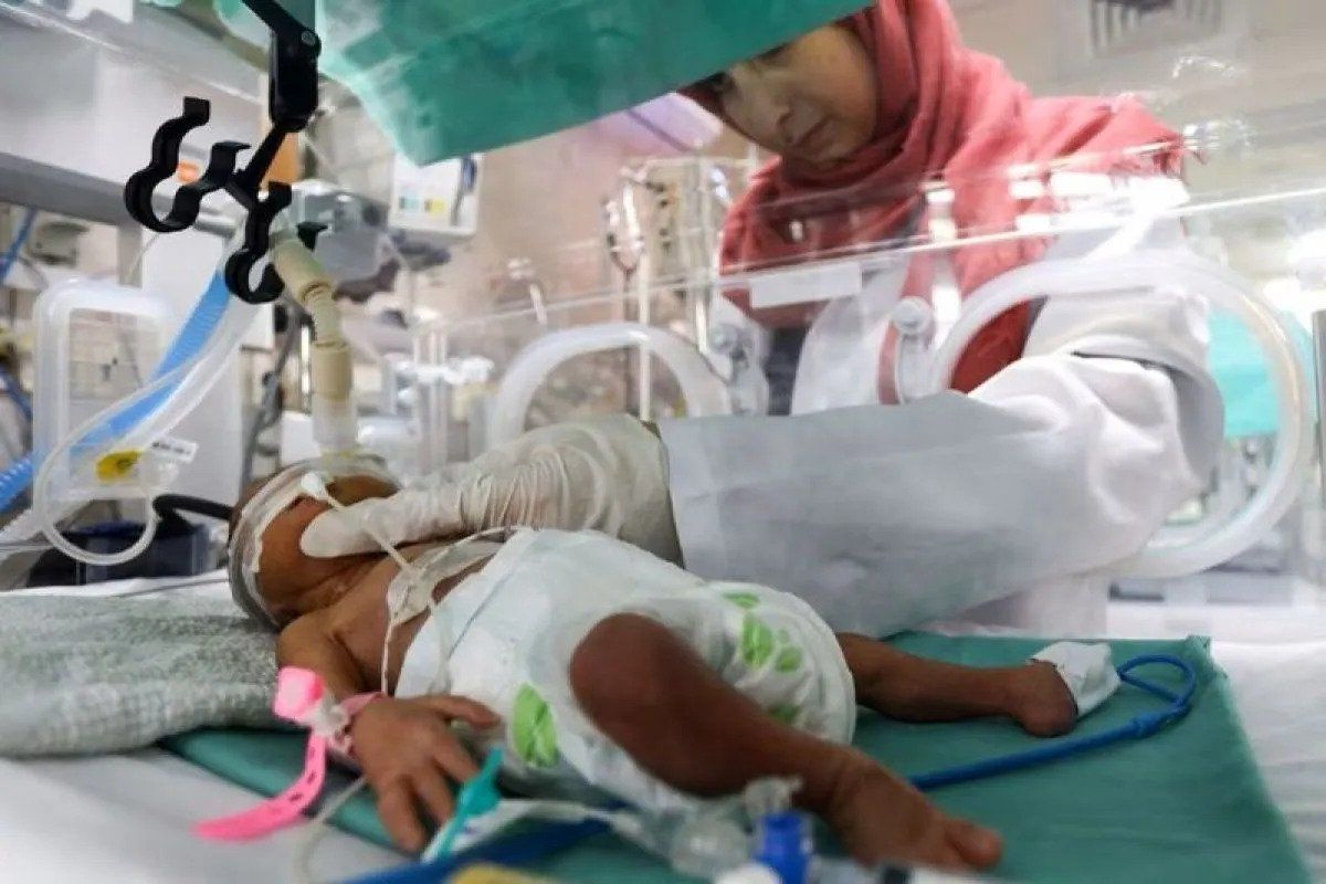 Seorang petugas merawat bayi prematur yang terbaring di inkubator di bangsal bersalin Rumah Sakit Shifa, yang menurut pejabat kesehatan akan ditutup karena kehabisan bahan bakar dan listrik, di tengah konflik Israel-Hamas, di Kota Gaza, 22 Oktober 2023.