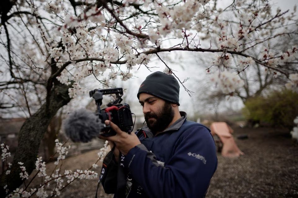 Jurnalis Reuters Issam Abdallah mengambil foto selfie saat bekerja di Maras, Turki, 11 Februari 2023. 