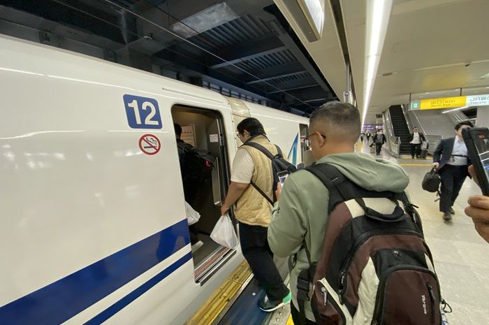Para penumpang Shinkansen tujuan Shinagawa-Kakegawa memasuki kereta mereka.