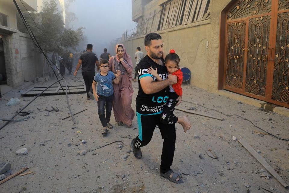 Warga Palestina mengevakuasi lokasi serangan Israel terhadap rumah-rumah, di tengah konflik yang sedang berlangsung antara Israel dan kelompok Islam Palestina Hamas, di kamp pengungsi Maghazi di Jalur Gaza tengah, 6 November 2023. 