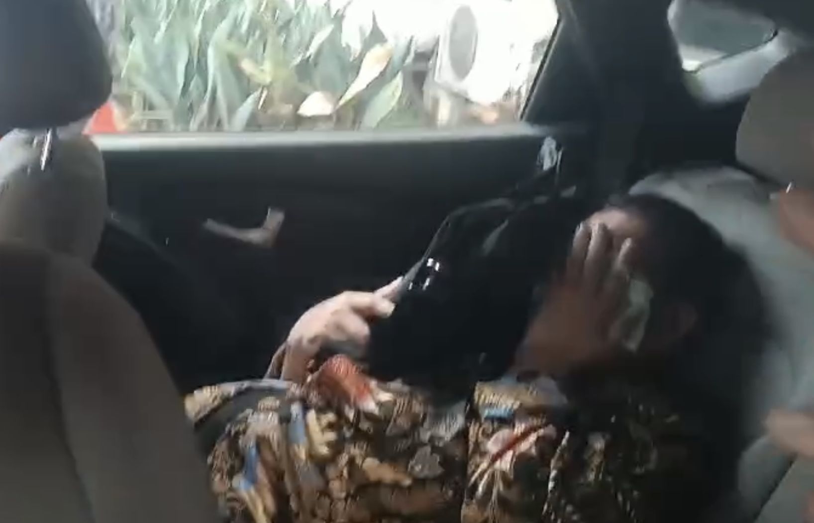 Beredar luas foto Ketua KPK Firli Bahuri mengenakan kemeja batik berbaring di mobil menutupi wajah dengan masker dan tas tangan.