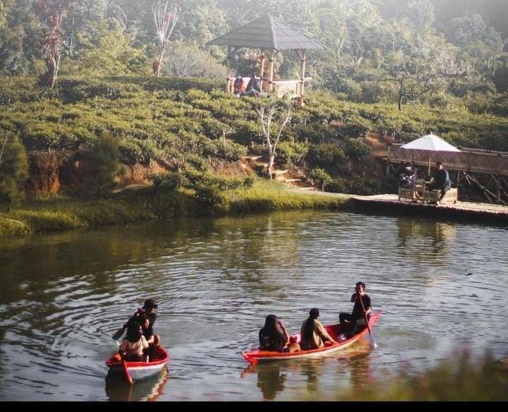 Wisatawan yang sedang mencoba wahan wisata alam di Sumedang dengan keindahan danau dan alam yang asri.