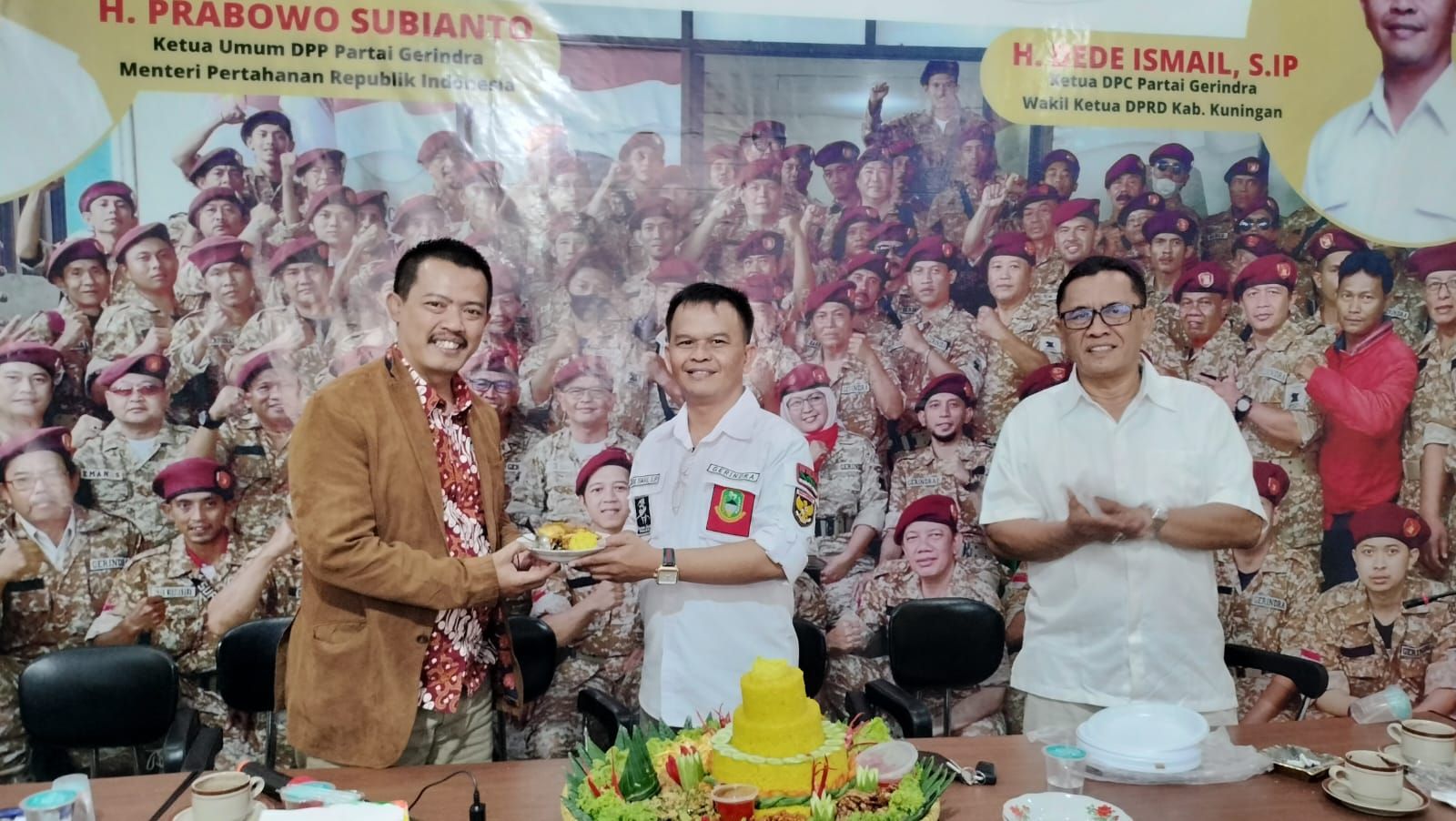 Ketua DPC Gerindra Kuningan, H. Dede Ismail memberikan potongan nasi tumpeng pertama ke Ketua Tim Pemenangan Iwan Bule, H. Usman Kusman.