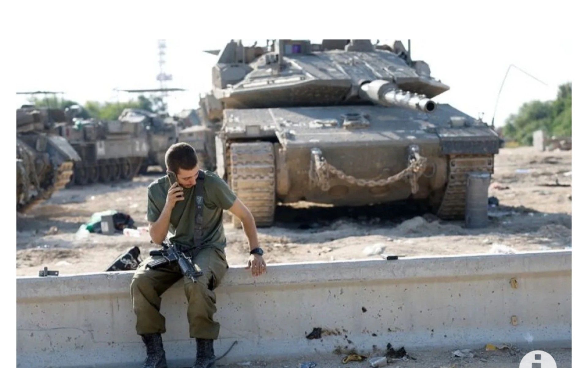 Seorang tentara Israel menggunakan telepon di samping tank, dekat perbatasan dengan Gaza, di Israel Selatan (17/11/2023).