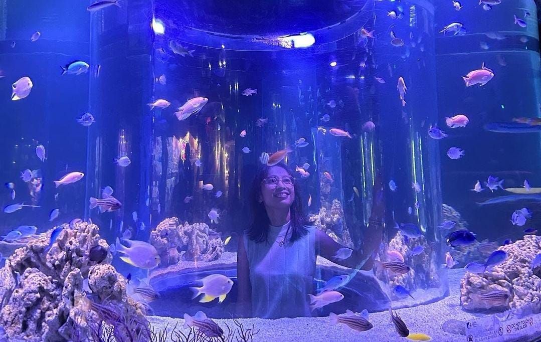 Terlihat seorang pengunjung sedang berfoto bersama aneka hewan laut di Jakarta Aquarium.