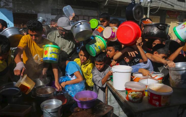Para anak-anak pengungsi Gaza sedang antri untuk mendapatkan bantuan makanan di Rafah, Gaza Selatan.
