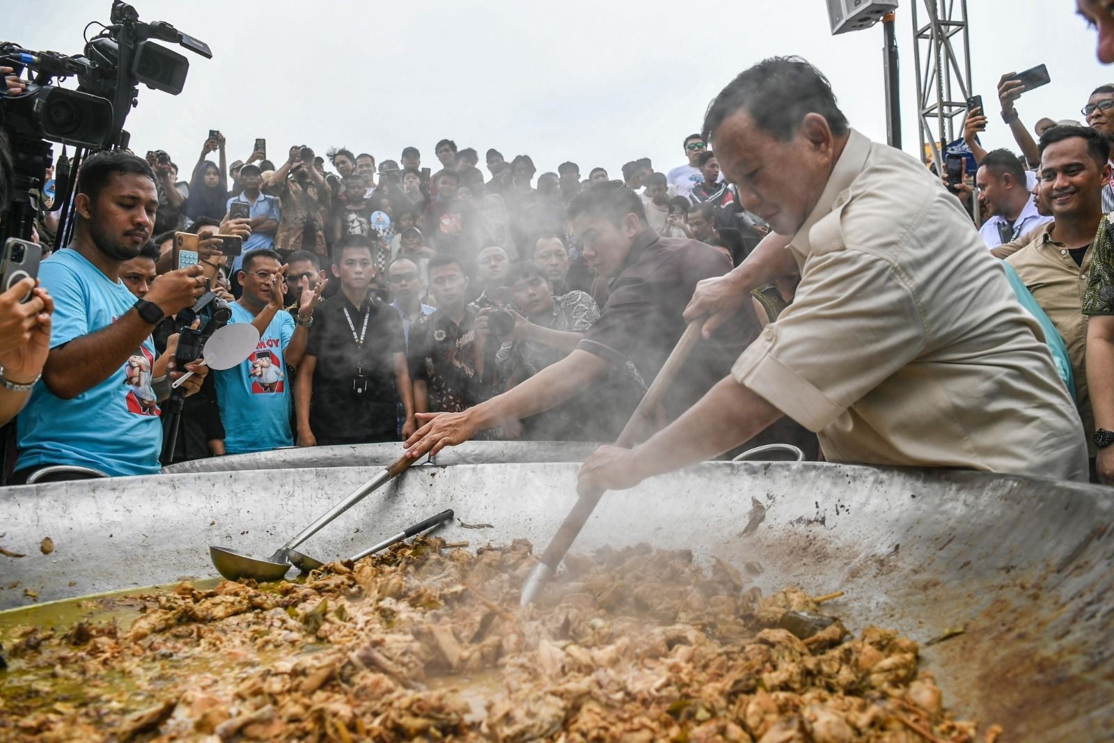 Prabowo Subianto mengaduk masakan saat acara Makan Besar bersama masyarakat di Kali Baru, Cilincing, Jakarta Utara