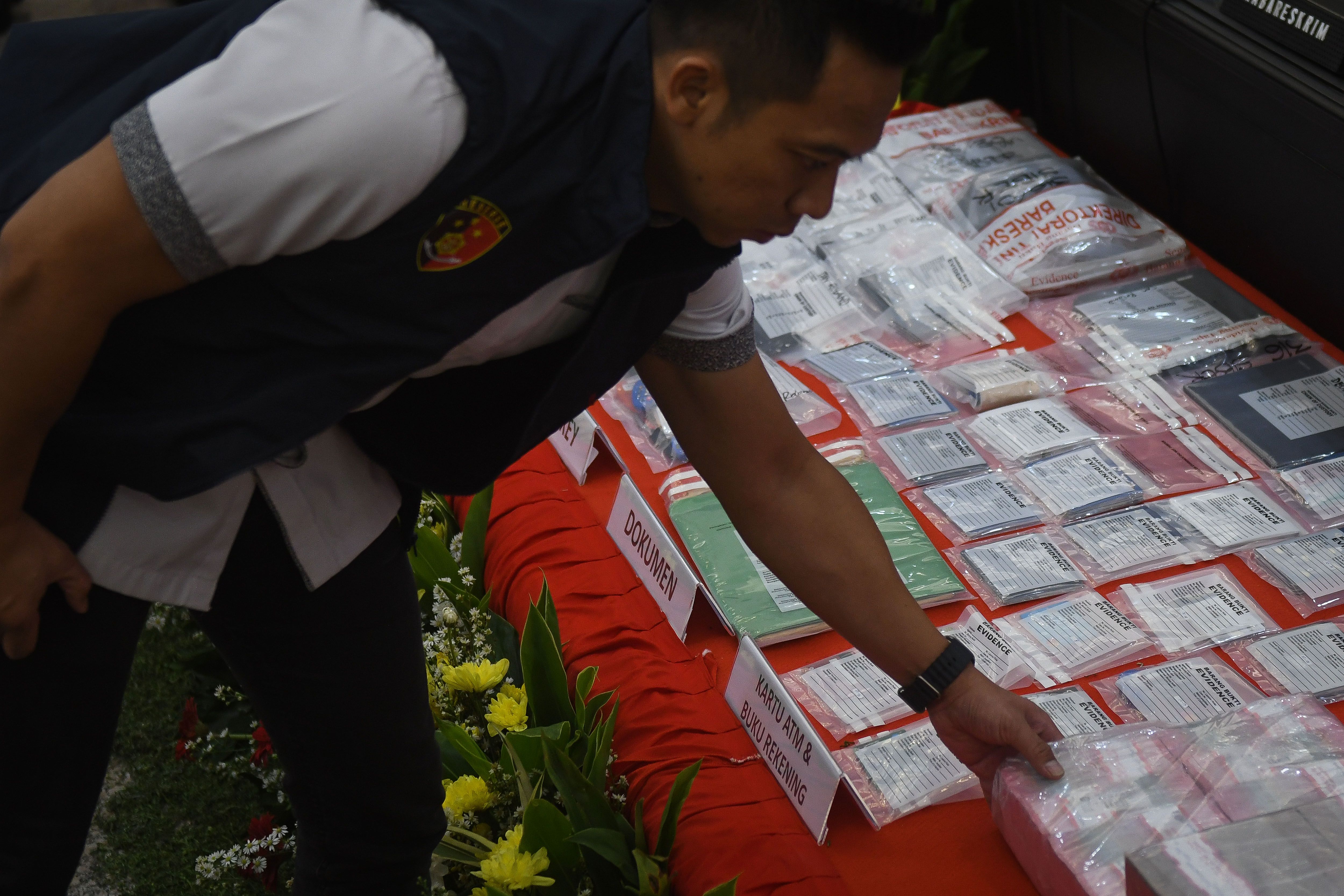 Petugas menata sejumlah barang bukti dalam konferensi pers kasus dugaan judi daring terkait kompetisi sepak bola Indonesia di Mabes Polri, Jakarta, Rabu, 13 Desember 2023.